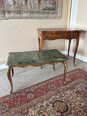 une table avec un plateau en marbre et un tapis posé au sol