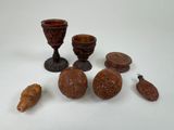 Plusieurs pièces de bois sculpté sont posées sur une surface blanche