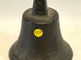 une cloche noire sur laquelle est collé un autocollant jaune