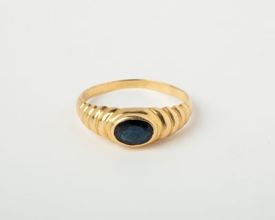une image d'une bague en or avec une pierre bleue