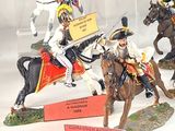 many figurines of men riding horses in a display case