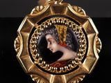 un pendentif plaqué or représentant le portrait d'une femme coiffée d'une couronne