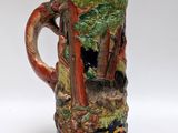 a beer mug that has a picture of a forest scene on it