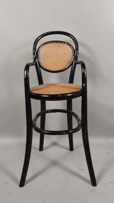 une image représentant une chaise noire avec une assise en osier sur fond blanc
