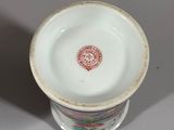 a white cup with a red and green design on it