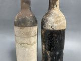 deux bouteilles de vin posées l'une à côté de l'autre sur une surface grise