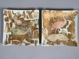 pair of decorative plates with birds on them sitting on a table