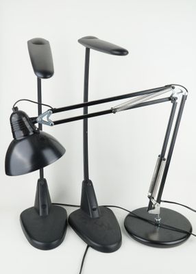 deux lampes de bureau noires posées sur une surface blanche, avec un fond blanc