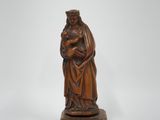 une vieille statue en bois représentant une femme tenant un enfant dans ses bras