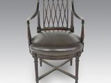une chaise ancienne avec une assise rembourrée de cuir et un cadre en bois