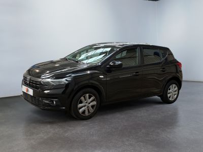 Une voiture noire est garée dans une grande pièce aux murs blancs.
