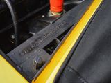 a close up of a yellow car engine with a red cap