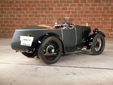a vintage car parked in front of a brick wall