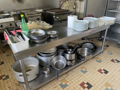 de nombreuses casseroles et poêles sur le plan de travail de la cuisine