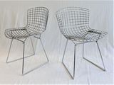 pair of chrome wire chairs on a white background with a white backdrop