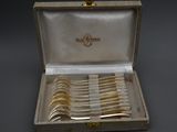 des couverts dans un coffret posé sur une table, sur fond noir