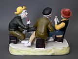three figurines of men sitting at a table