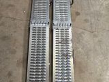 une paire de grilles métalliques posées sur un sol en béton
