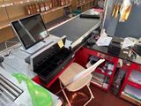a desk with a laptop and a printer in a store