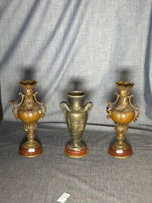 three gold vases sitting on top of a table next to each other