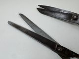 two pairs of scissors sitting on a white surface