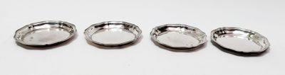quatre cuillères en argent posées sur une surface blanche