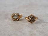 pair of gold and diamond stud earrings on a white surface