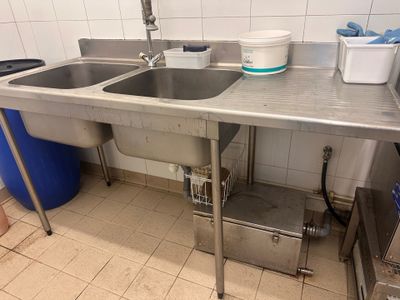 a sink and a trash can in the kitchen