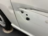 a white car with bullet holes on the side of it