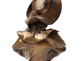 bronze statue of a woman with a hat on top of her head