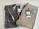 deux paires de pantalons pour homme posées sur un sac en plastique