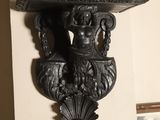 a statue of a woman on a shelf on the wall