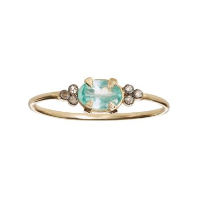 un gros plan d'une bague en or sertie d'une pierre verte et blanche