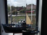 a small boat that is sitting in a window sill