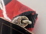 a close up of a red and black tie with a silver buckle