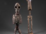 deux figurines sculptées représentant un squelette et un personnage humain