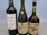 trois bouteilles de vin posées sur une table, l'une à côté de l'autre