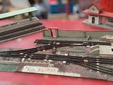 three model trains sitting on a table with a red table cloth