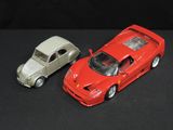 two toy cars sitting next to each other on a black surface