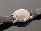a close up of a watch on a black surface