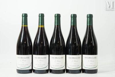 quatre bouteilles de vin sont alignées sur une surface blanche