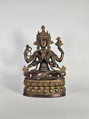 une statue en bronze représentant une femme assise sur une table