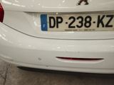 a white car parked in a parking lot with a number plate on it