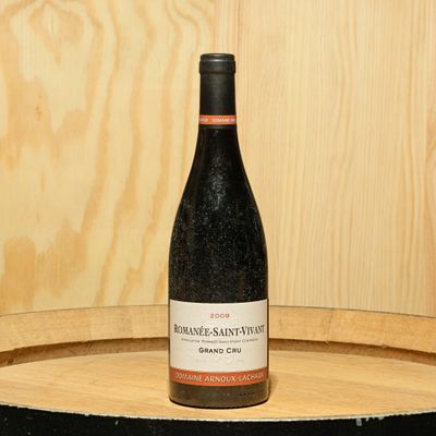 a bottle of wine sitting on top of a barrel
