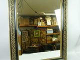 un miroir accroché au mur à côté d'une étagère