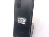 the back of a black samsung phone with a barcode sticker on it