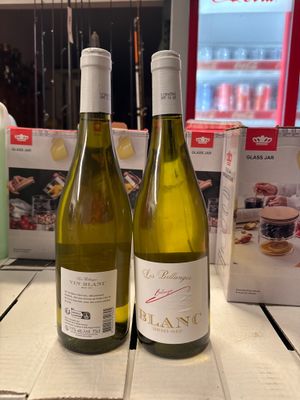 deux bouteilles de vin posées sur une table l'une à côté de l'autre