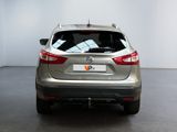the back of a silver car in a room with a white wall