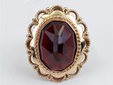 Gros plan sur une bague contenant une pierre rouge