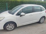 a small white car parked on the side of the road